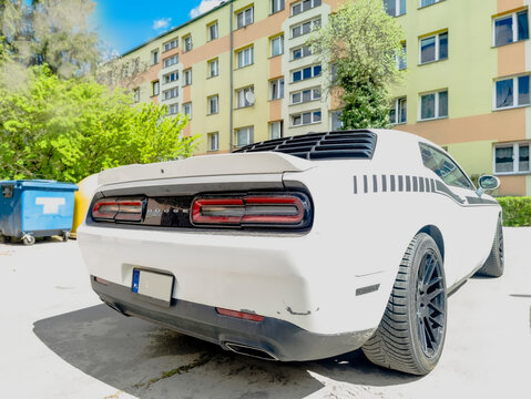 Polska, Ostrowiec Świętokrzyski, 24 kwietnia 2026, 12:16. Dodge Challenger, biały amerykański muscle car wiosną, przed Lidlem. Samoch&oacute;d wyr&oacute;żnia się charakterystycznym designem tyłu z czarnymi pasami 