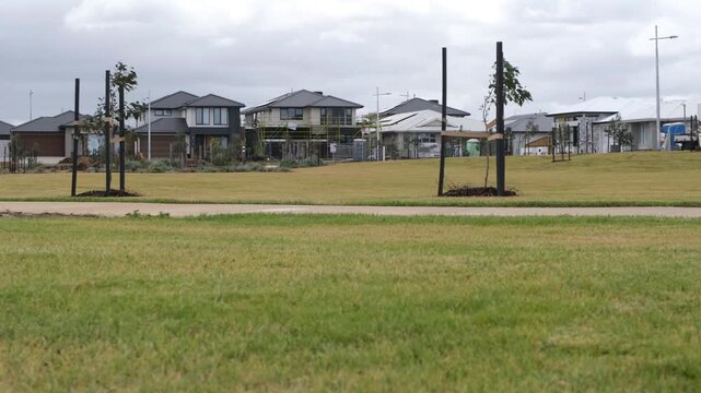 A contemporary housing estate in Tarneit with young saplings and modern houses. Concept of  urban sprawl, green space planning and master-planned community growth in Melbourne Australia