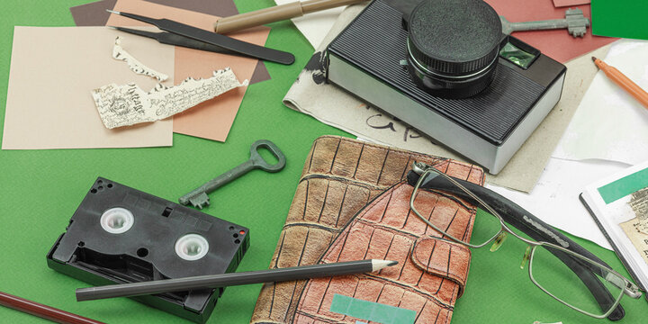 Flat lay with vintage camera, cassette, notebook, key and research tools on green background
