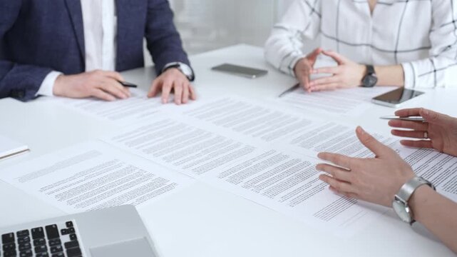 Business people discussing contract terms, outlining agreements, and reviewing legal documents during a corporate meeting, preparing for a significant partnership signing and negotiation