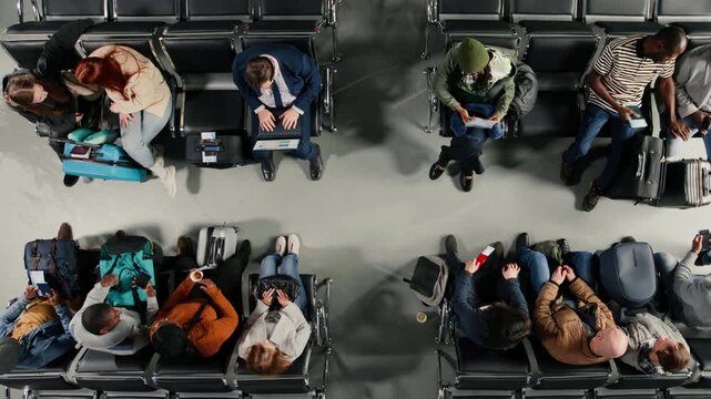Top down view of busy airport terminal filled with angry people annoyed by flight delay. Frantic travelers upset by flight cancelation, losing plane and holiday trips, high angle shot