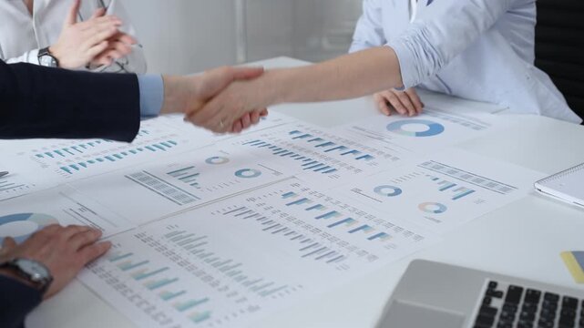 Business executives shaking hands, sealing an agreement after successful negotiations in a bright office, symbolizing partnership, collaboration, and a mutually beneficial deal signing