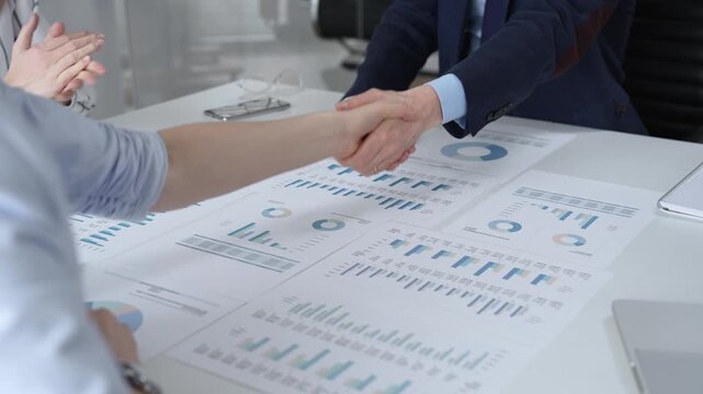 Business executives shaking hands, sealing an agreement after successful negotiations in a bright office, symbolizing partnership, collaboration, and a mutually beneficial deal signing