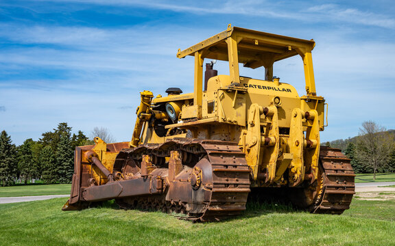 Prairie du Chien, Wisconsin, United States - April 26, 2026 - Photo of a vintage Caterpillar buldozer parked on the lawn of a local construction company on a beautiful spring day