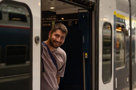 Voyageur descendant d&rsquo;un train en gare avec sac &agrave; dos et bagages