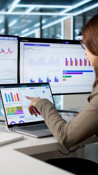 Business Analyst Reviews Financial Charts On Computer
