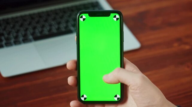 Green screen smartphone, mobile phone mockup, chroma key, hand holding device