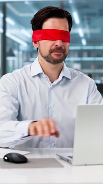 Blindfolded Businessman Works Focused On Laptop
