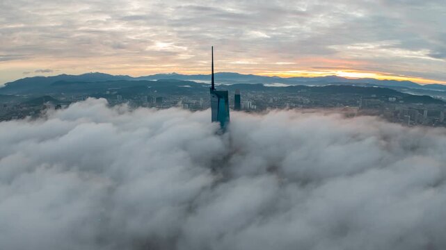 Aerial view time lapse 4k video of Kuala Lumpur city center view during dawn overlooking the city skyline in Federal Territory, Malaysia with epic low cloud glows on sunrise. 