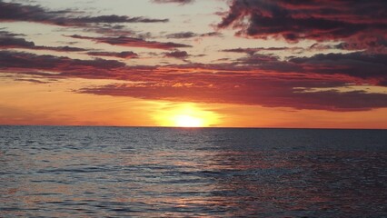 Fototapeta premium Dramatic golden beach sunset sky and tropical sea background. yellow sun sets behind the lake. Beautiful sunrise on the lake. Protect the environment. sun sets ha horizon
