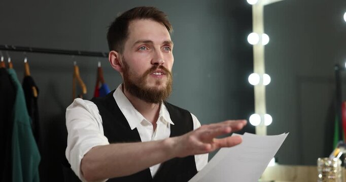 Actor with script rehearsing his lines in dressing room