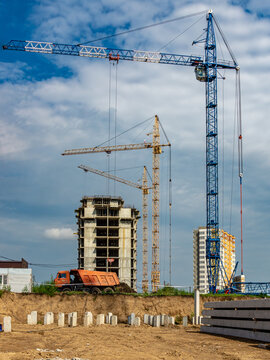 Construction site with tower cranes and multistory building frame showing urban territory development and infrastructure expansion