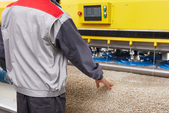 Male worker cleaning carpet on automatic washing machine equipment and dryer in the Laundry room. professional washing service