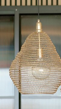 Vertical video: Shots moving, cam closing on woven metal shade before ribbed glass showing weave