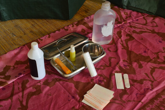 An extreme high perspective from the left side capturing surgical scissors, gauze bandages, and antiseptic solutions gathered together for a comprehensive first aid treatment setup.