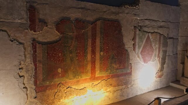 High-quality 4K cinematic footage of preserved ancient Roman wall frescoes depicting standing figures in the Villa of the Muses at the Zeugma Mosaic Museum in Gaziantep, Turkey.