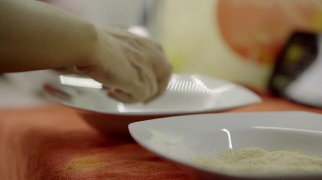 Closeup view of hand cracking egg into bowl with flour nearby, simple kitchen scene highlighting ingredient preparation and cooking process for homemade meal