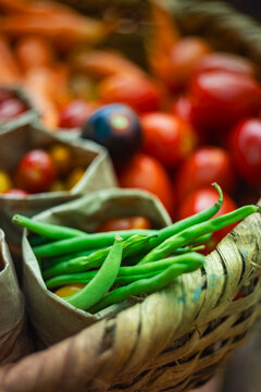 Fresh Organic Green Beans and Heirloom Tomatoes in Rustic Wicker Basket with Copy Space