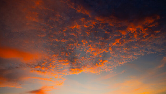 vibrant sunset cloudscape panorama with scattered clouds and teal sky