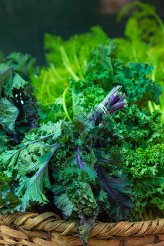 Fresh Organic Purple Stem Kale Bundle in Rustic Wicker Basket at Local Farmers Market