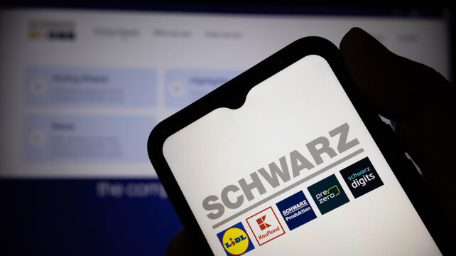 Closeup of a smartphone screen displaying the schwarz group logo and its subsidiary brands including lidl, kaufland, schwarz produktion, prezero, and schwarz digits