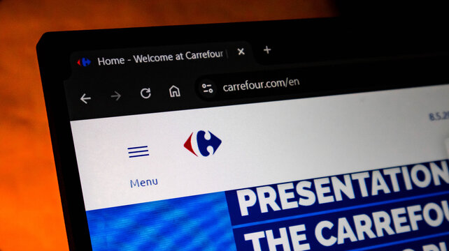 Laptop screen displaying the carrefour official website homepage with logo and menu in a web browser