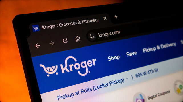Closeup of a laptop screen displaying the kroger grocery store website homepage in a web browser