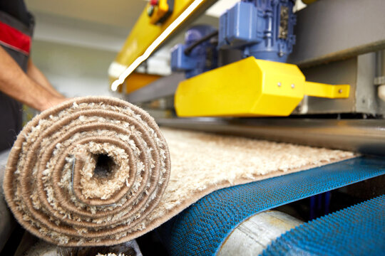 Male worker cleaning carpet on automatic washing machine equipment and dryer in the Laundry room. professional washing service