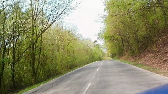 Spring road ride on local road through forested area, upland of Myjava region, western Slovakia. Mostly oak an beech broadleaf trees around with first spring leaves