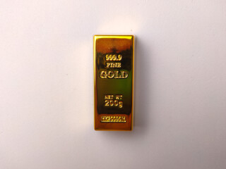 A single 200g fine gold bullion bar is centered on a plain white background, showing its reflective surface © Mohd Azrin