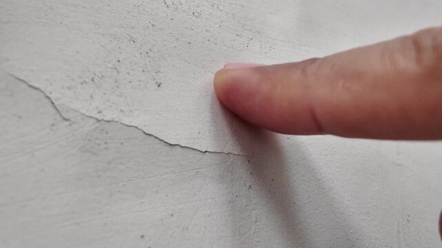 Footage tracking a long, deep horizontal crack across a concrete wall, indicating potential structural settling or stress.