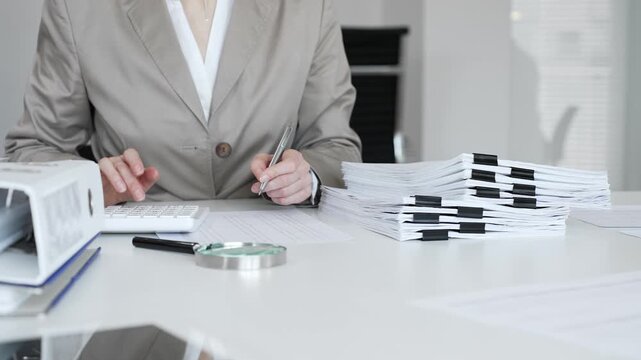 Businesswoman hands organizing stack of papers with binder clips, working on financial documents and official reports in office. Audit and taxes concept