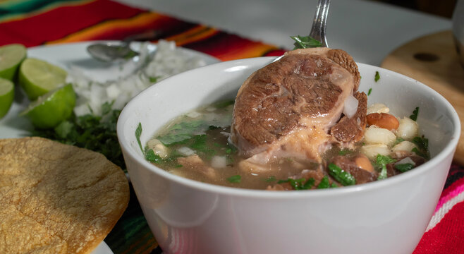 Mexican food, a typical dish from northwest Mexico (Sonora) with corn and cooked beans, with beef in soup with cilantro and chopped onion, GALLINA PINTA, with corn tortillas on the side