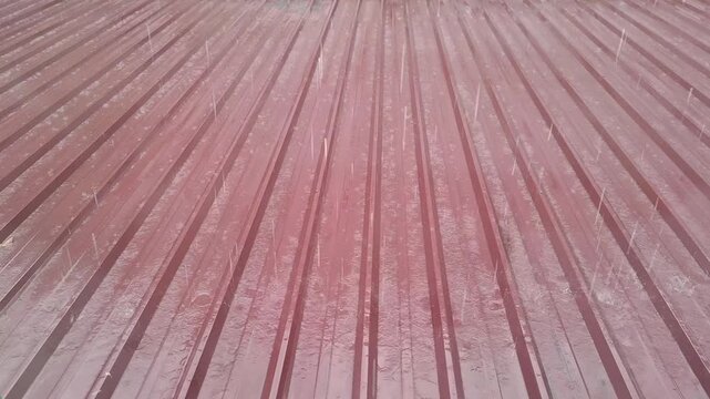 Close-up of weathered red corrugated metal roofing with rust and texture