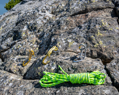 Climbing gear for anchor building on rocky surface with bright rope under clear sky  nature