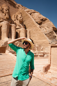 Stylish tourist posing beside the colossal statues of Ramesses II at Abu Simbel