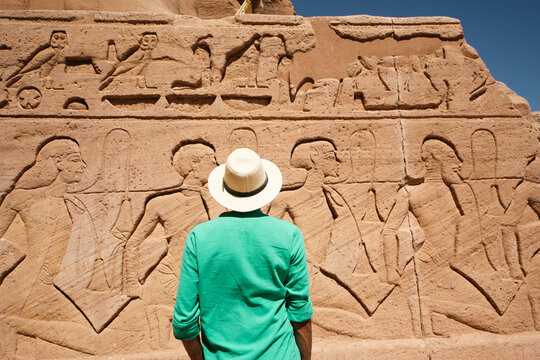 Traveler admiring ancient Egyptian relief carvings at Abu Simbel Temple