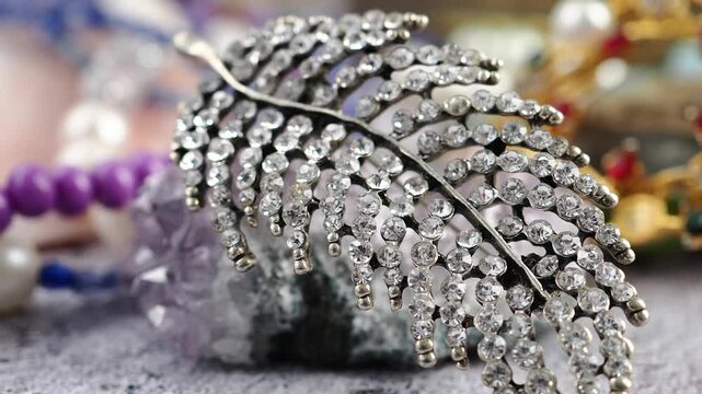 Jewelry display showing a leaf brooch and other items