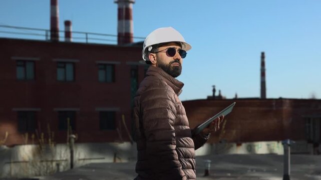 Project Leader In Safety Equipment Inspecting Industrial Rooftop And Coordinating Maintenance Tasks Thoroughly. Media