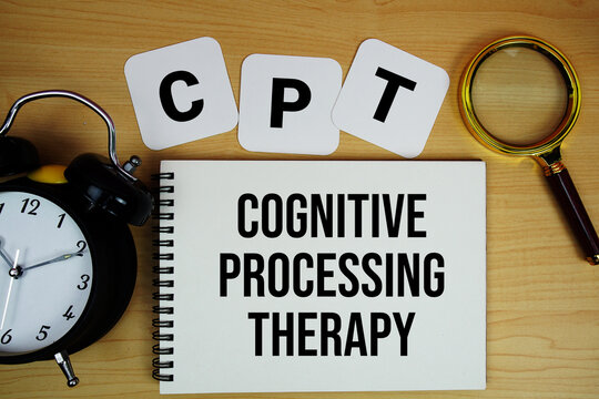 CPT Cognitive Processing Therapy text written on notepad with magnifying glass and alarm clock on wooden background