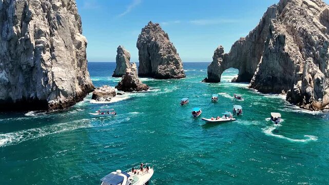 Drone flying over a group of boats near El Arco de Cabo San Lucas, moving toward the iconic rock formation at Land&rsquo;s End.