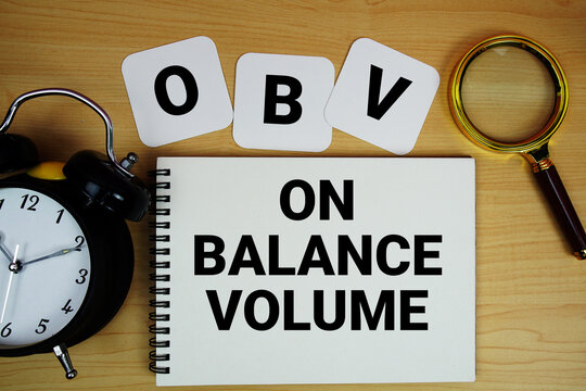 OBV On Balance Volume text written on notepad with magnifying glass and alarm clock on wooden background