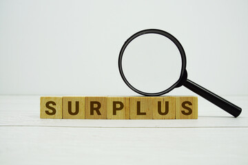 SURPLUS alphabet letters with magnifying glass on wooden background © may1985