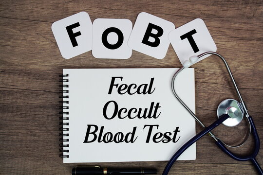 FOBT Fecal Occult Blood Test text written on notepad with stethoscope on wooden background