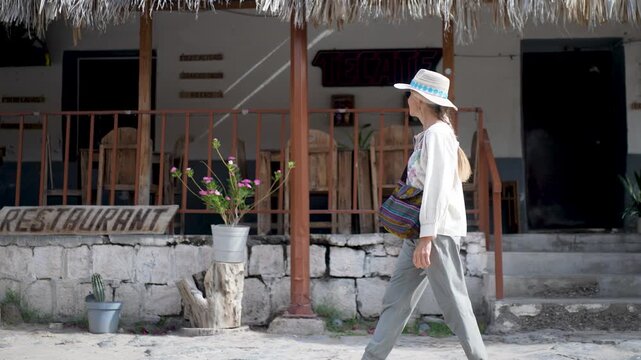 Mature woman walks along the streets of San Ignacio, discovering the shops and the mission on a warm day in Baja California Sur, Mexico