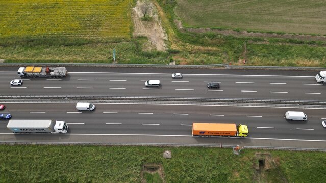 Highway Traffic Flow: Aerial view showcasing a busy highway filled with a diverse array of vehicles navigating the open road, set against a backdrop of natural landscapes. 
