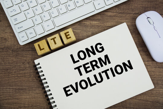 LTE Long-Term Evolution message with keyboard and optical mouse on wooden background