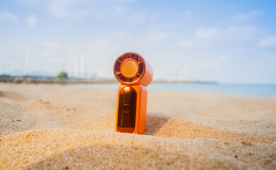 Obraz premium Portable handy fan on the beach and the background is the sea and the sky in summer.