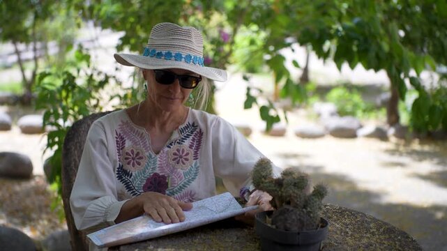Mature woman studies a map in the Mission town of San Ignacio in Baja California Sur, Mexico while learning about the local culture and history.