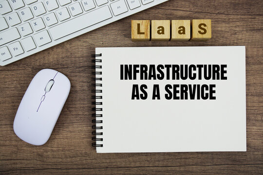 IaaS Infrastructure as a Service message with keyboard and optical mouse on wooden background